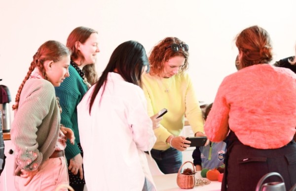 A group of people of various ages are gathered around a table, engaged in a craft activity.