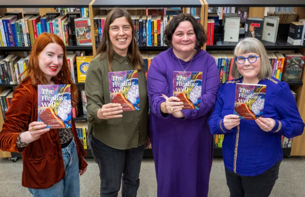 Four people standing with books in their hands