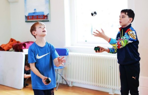 two children playing with balls in a room