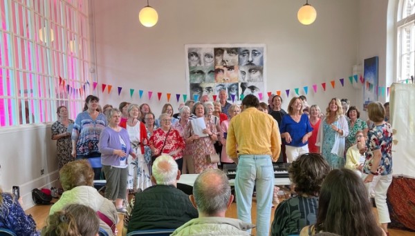 A choir of people singing, and an individual playing a keyboard